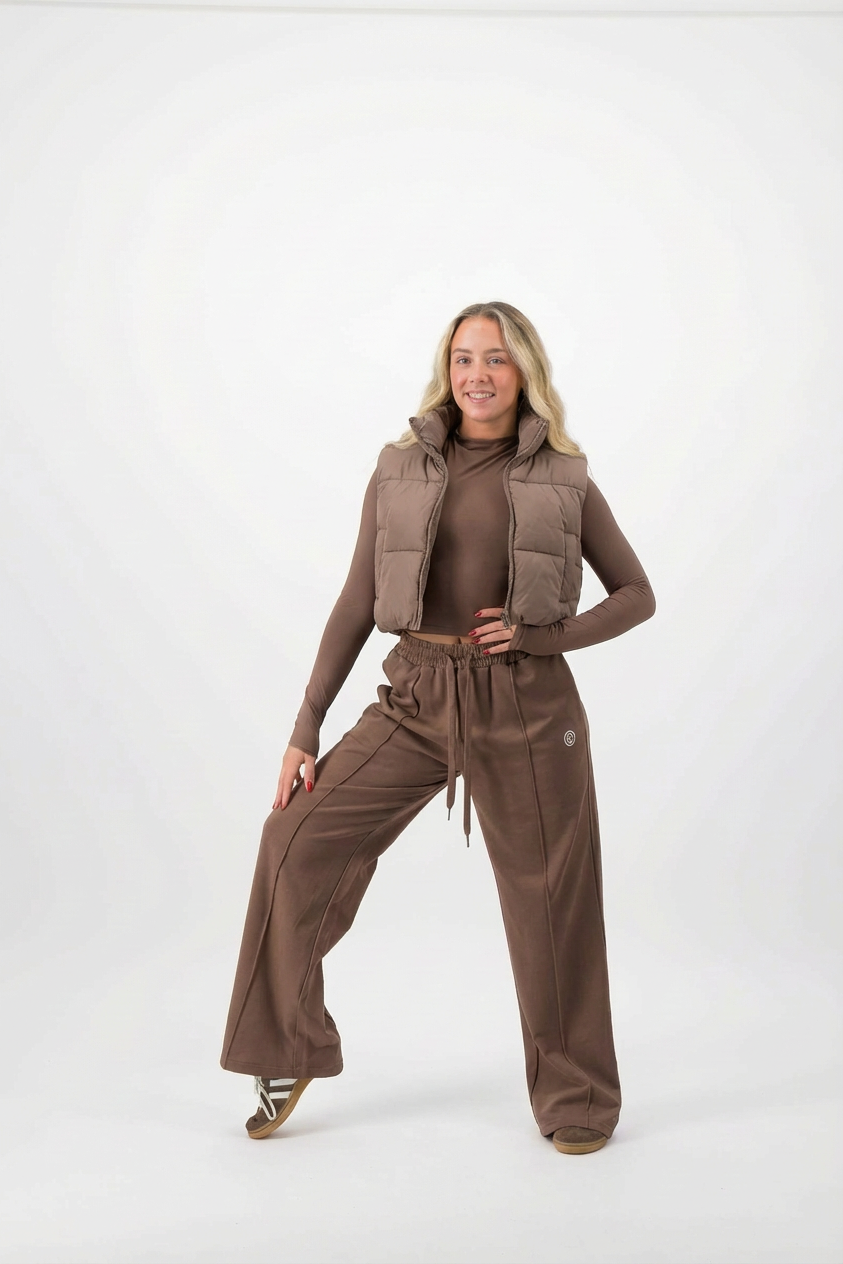 Woman wearing a brown outfit with a vest on a white background