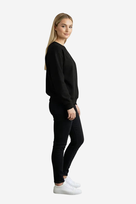 Woman wearing a dark gray sweatshirt and black pants against a plain background