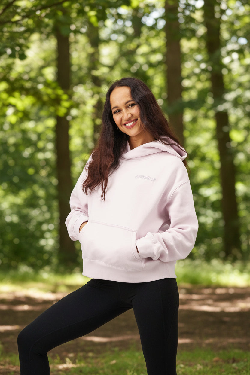 Woman wearing a light pink hoodie on a white background