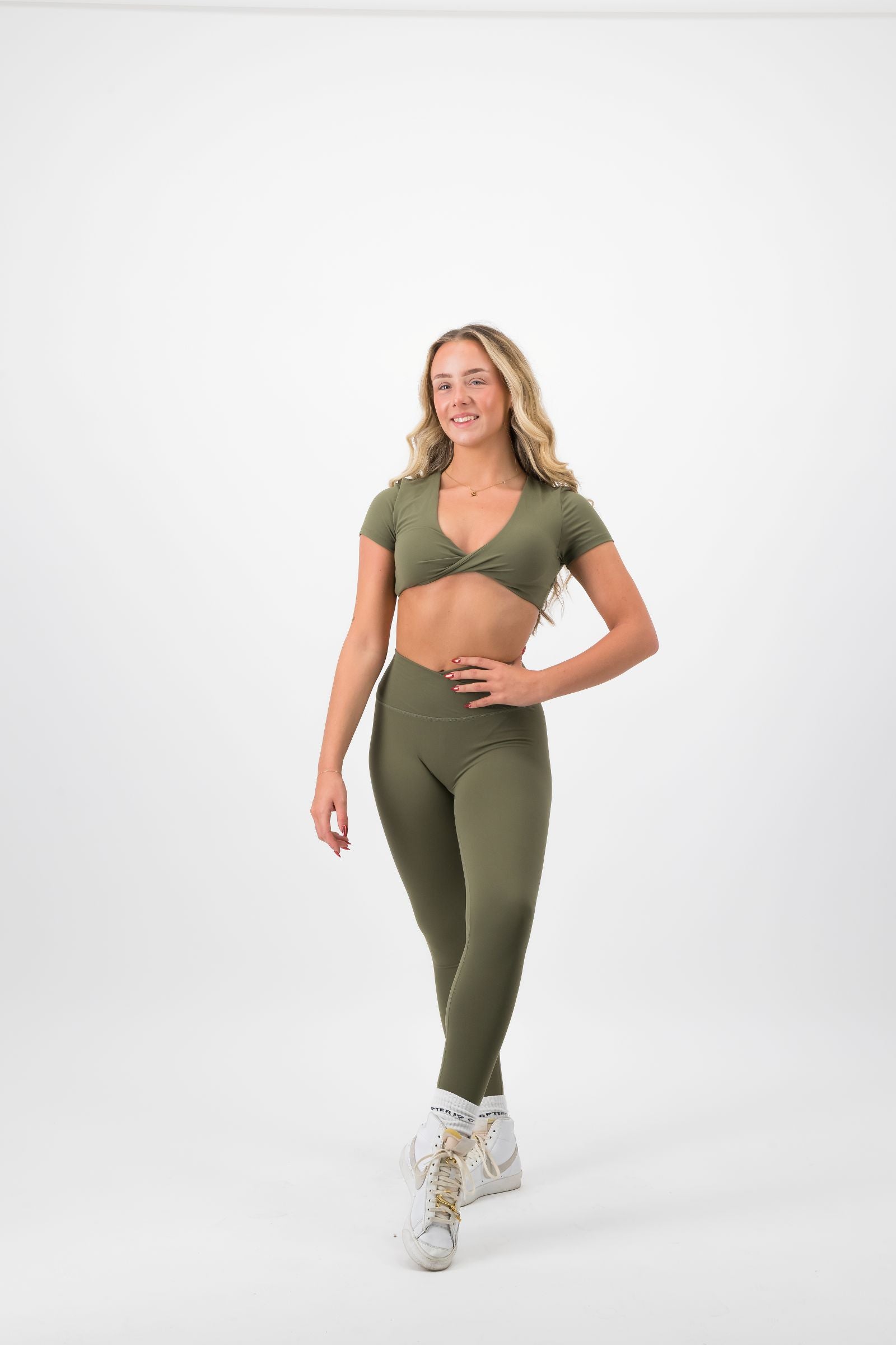 Woman wearing a green athletic outfit on a white background