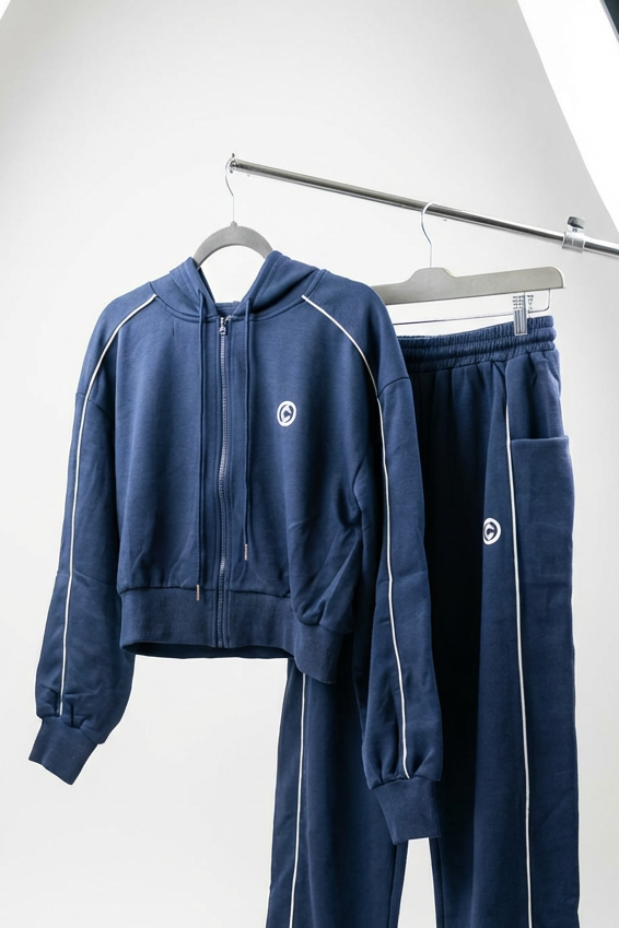 Navy tracksuit with beige towel on a white background
