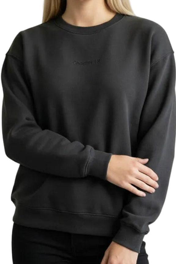 Woman wearing a black sweatshirt against a beige background