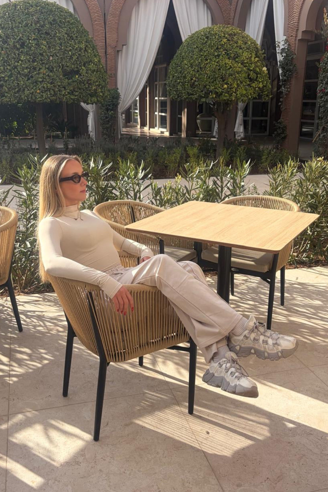 Woman sitting at an outdoor cafe with a scenic background